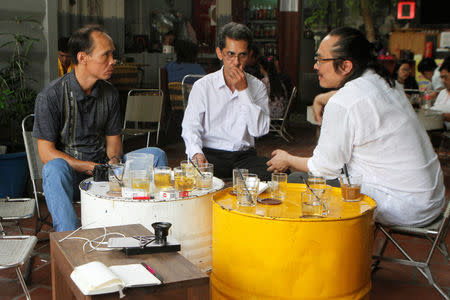 Vietnamese deportees and Amerasians Bui Thanh Hung (L) and Pham Chi Cuong (C) speaks to U.S. lawyer and Vietnamese-American Tin Nguyen at a cafe in the suburbs of Ho Chi Minh City, Vietnam April 19, 2018. Picture taken April 19, 2018. REUTERS/James Pearson