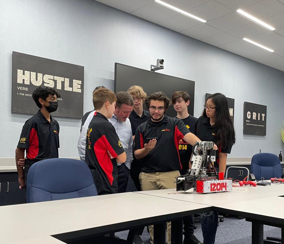 The Fire Wires robotics team demonstrates their robot to State Rep. Chuck Goodrich (R-Noblesville). The team was instrumental in getting legislation passed for robotics funding in Indiana.