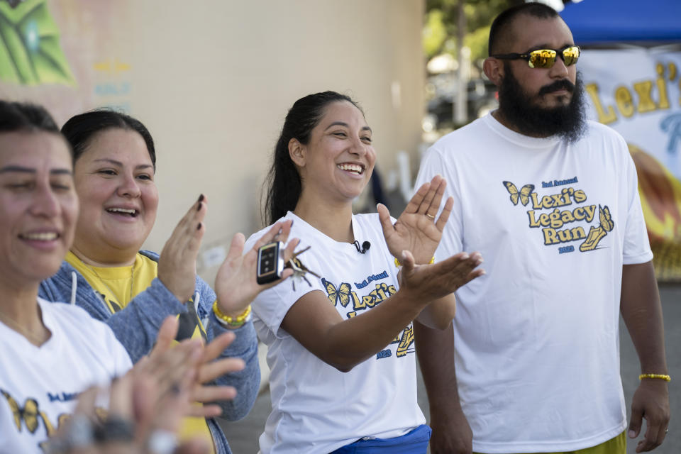 Uvalde mayoral candidate Kimberly Mata-Rubio, second from right, applauds race finishers alongside her husband, Felix Rubio, right, after the second annual Lexi's Legacy Run, Saturday, Oct. 21, 2023, in Uvalde, Texas. (AP Photo/Darren Abate)