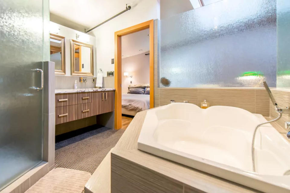 <p>The master bathroom is large and features a separate tub and shower.<br>(Airbnb) </p>