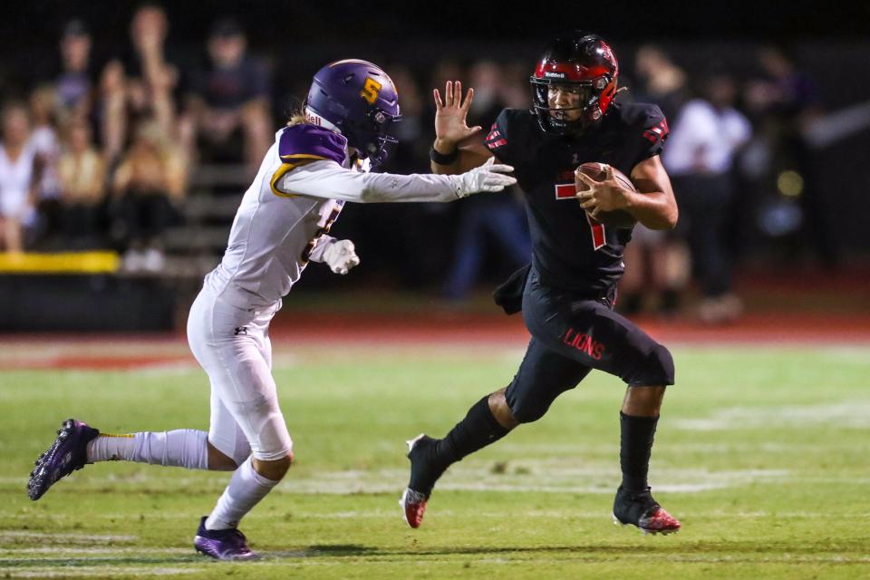 Liberty quarterback Navi Bruzon (7), right, holds off Sunrise Mountain Austin Roark (5) as he makes a run down the line against Sunrise Mountain on Friday, September 2, 2022, in Peoria. The game ended 50-0 to Liberty.