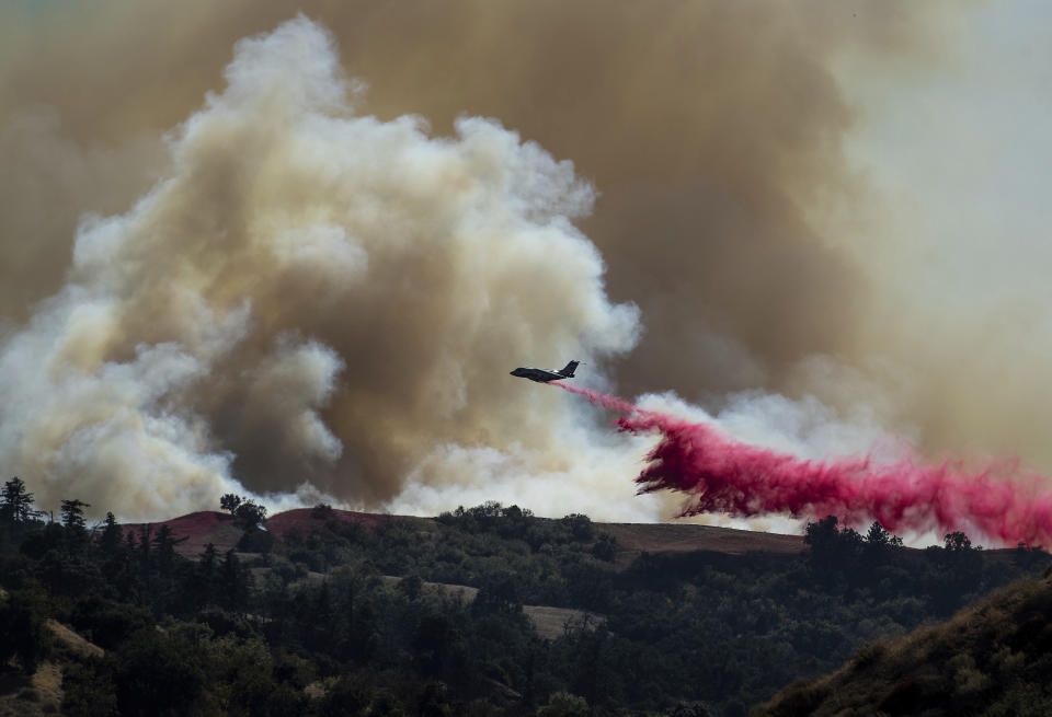 A tanker drops retardant on the Saddleridge Fire burning in Newhall, Calif., on Friday, Oct. 11, 2019. (AP Photo/Noah Berger)