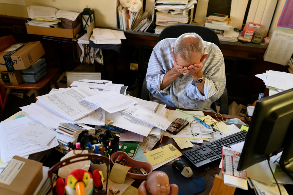 In his office at Youth Services System, a non-profit charity, John Moses listens to voicemail from dozens of people requesting help before the holidays on Dec. 11.<span class="copyright">Rebecca Kiger</span>