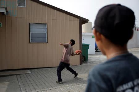 A Honduran migrant child plays with a football at the Senda de Vida migrant shelter in Reynosa, in Tamaulipas state, Mexico June 22, 2018. Picture taken June 22, 2018. REUTERS/Daniel Becerril