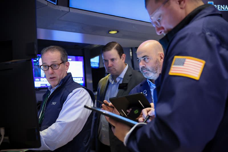 FILE PHOTO: Traders work on the floor of the NYSE in New York