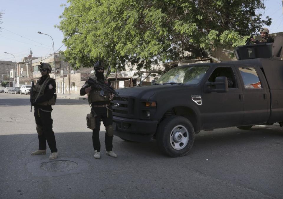 Members of Iraq's Special Weapons and Tactics Team (SWAT) stand guard in front of a polling station in Baghdad, Iraq, Wednesday, April 30, 2014. A key election for a new Iraqi parliament was underway on Wednesday amid a massive security operation as the country continued to slide deeper into sectarian violence more than two years after U.S. forces left the country. (AP Photo/ Khalid Mohammed)