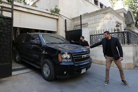 Bodyguards gesture towards a vehicle carrying Marine Le Pen, French National Front (FN) political party leader and candidate for French 2017 presidential election, as she leaves the Dar al-Fatwa building after she refused to wear a headscarf for her meeting Lebanon's Grand Mufti Sheikh Abed el-Lateef Daryan in Beirut, Lebanon February 21, 2017. REUTERS/Aziz Taher