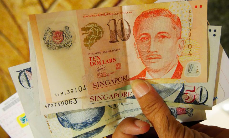 Singapore, Singapore-March 2016: Singapore dollar bills held by a hand, close up.