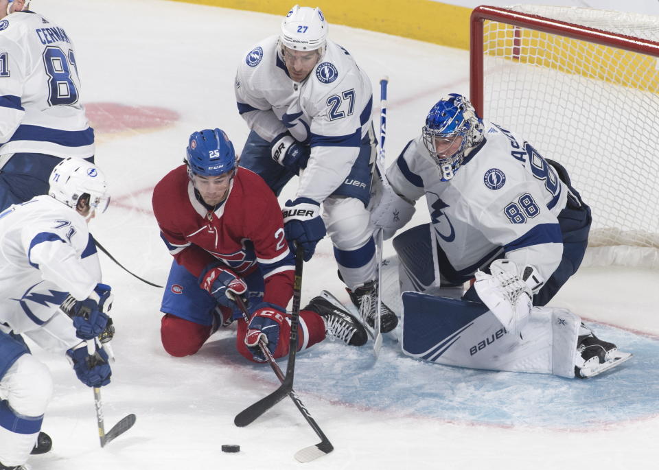 Montreal Canadiens' Ryan Poehling (25) moves in on Tampa Bay Lightning goaltender Andrei Vasilevskiy as Lightning's Ryan McDonagh (27) and Anthony Cirelli (71) defend during the second period of an NHL hockey game Thursday, Jan. 2, 2020, in Montreal. (Graham Hughes/The Canadian Press via AP)