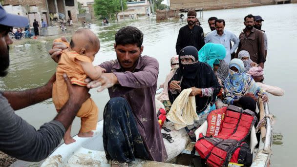 PHOTO: Residents arrive in a boat to a safer place after being evacuated following heavy monsoon rainfall in the flood affected area of Rajanpur district in Punjab province, Aug. 24, 2022.  (Shahid Saeed Mirza/AFP via Getty Images)