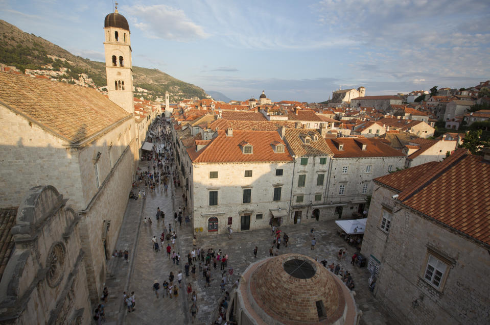 In this Sept. 7, 2018 photo, tourists walk through Dubrovnik old town. Crowds of tourist are clogging the entrances into the ancient walled city, a UNESCO World Heritage Site, as huge cruise ships unload thousands more daily. (AP Photo/Darko Bandic)