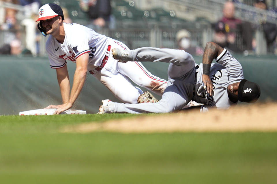 Chicago White Sox shortstop Tim Anderson, right, stays on the ground after a collision with Minnesota Twins' Matt Wallner while covering third base during the fourth inning of a baseball game, Monday, April 10, 2023, in Minneapolis. (AP Photo/Abbie Parr)