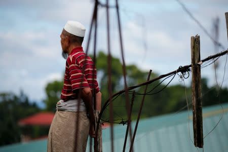 A Muslim man watches from a rooftop as Philippines army continue their assault against insurgents from the Maute group in Marawi City, Philippines June 28, 2017. REUTERS/Jorge Silva