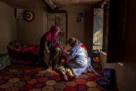 An elderly Kashmiri woman Arsha Begum receives the Covishield vaccine for COVID-19 from Fozia, a healthcare worker, during a COVID-19 vaccination drive in Budgam, southwest of Srinagar, Indian controlled Kashmir, Jan. 11, 2022. (AP Photo/Dar Yasin)