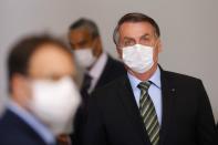 Brazil's President Jair Bolsonaro wearing a protective face mask arrives to a press conference to announce federal judiciary measures to curb the spread of the coronavirus disease (COVID-19) in Brasilia