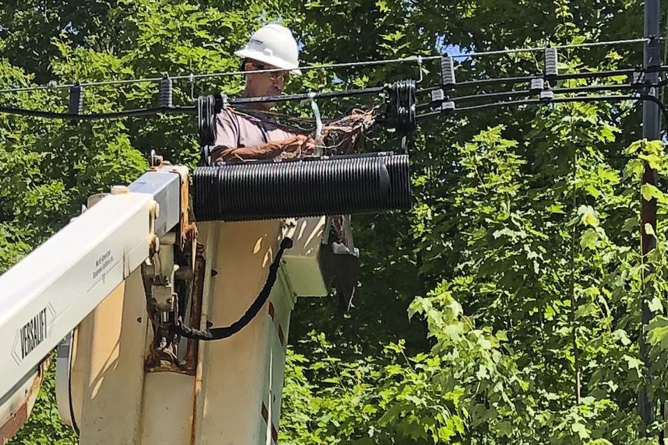 A Consolidated Communications technician works on a line used to provide broadband internet service in a rural area on Wednesday, July 29, 2020, in Stowe, Vt. Vermont officials are working to expand internet service using federal pandemic relief funds. But they are scrambling because the projects, which can frequently take years to plan and build, must be done by the end of the year. (AP Photo/Wilson Ring)