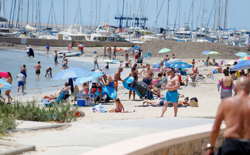 FILE PHOTO: People sunbathe on Playa de Palma beach in Mallorca