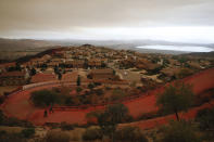 <p>Two police officers walk up a road covered with fire retardant as firefighters continue to battle a wildfire Wednesday, Aug. 8, 2018, in Lake Elsinore, Calif. (Photo: Jae C. Hong/AP) </p>