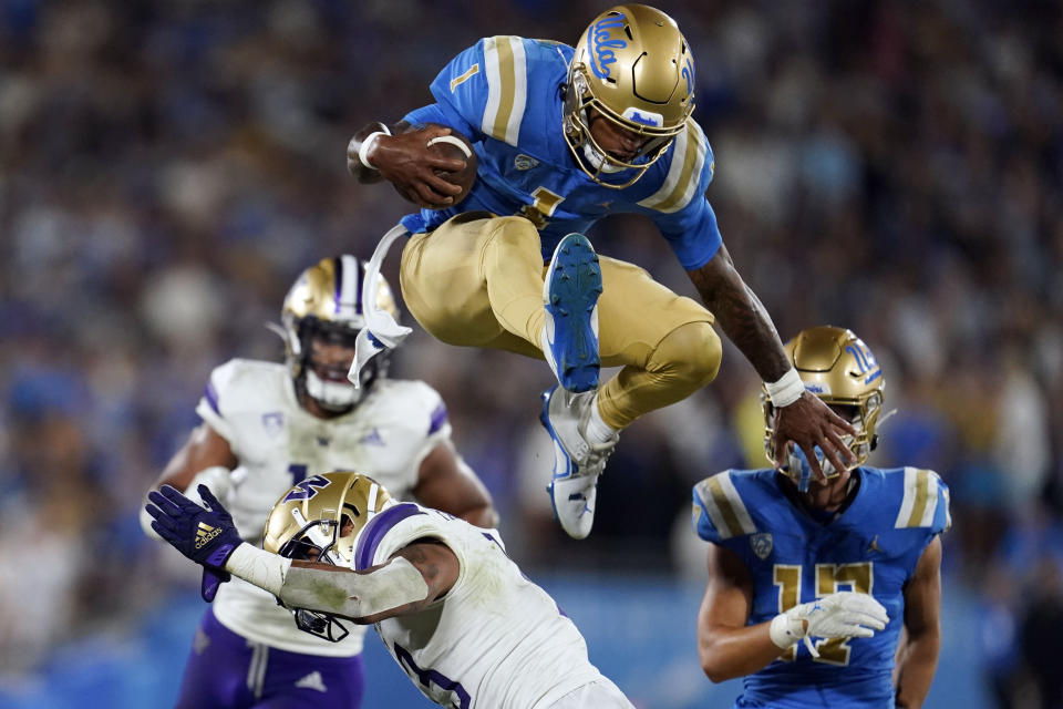 UCLA quarterback Dorian Thompson-Robinson (1) leaps over Washington linebacker Kamren Fabiculanan during the first half of an NCAA college football game Friday, Sept. 30, 2022, in Pasadena, Calif. (AP Photo/Marcio Jose Sanchez)