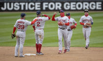 Boston Red Sox celebrate a 4-2 win over the Minnesota Twins in a baseball game Tuesday, April 13, 2021, at Target Field in Minneapolis. In the background is a sign about George Floyd. (Elizabeth Flores/Star Tribune via AP)