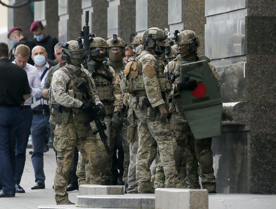 Ukraine's special police prepare to storm a city bank in Kyiv, Ukraine, Monday, Aug. 3, 2020, after a man has threatened to blow up an explosive device inside the bank. The man, identified as Sukhrob Karimov, a 32-year-old citizen of the Central Asian nation of Uzbekistan, entered a bank office in Kyiv and said he had explosives in his backpack. He let bank clerks go and demanded that the authorities invite journalists so that he could make a statement. (AP Photo/Efrem Lukatsky)