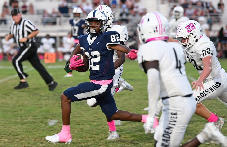 Parrish's wide receiver Rymen Mosley (82) gains first down yardage in the first quarter of play. Parrish Community High School Bulls win 35 to 28 over Braden River High Pirates during a district home game at the Bulls stadium Friday night, Oct. 13, 2023, in Parrish.