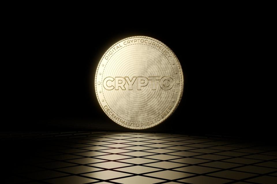 A metal coin with the word Crypto on it against a black background.