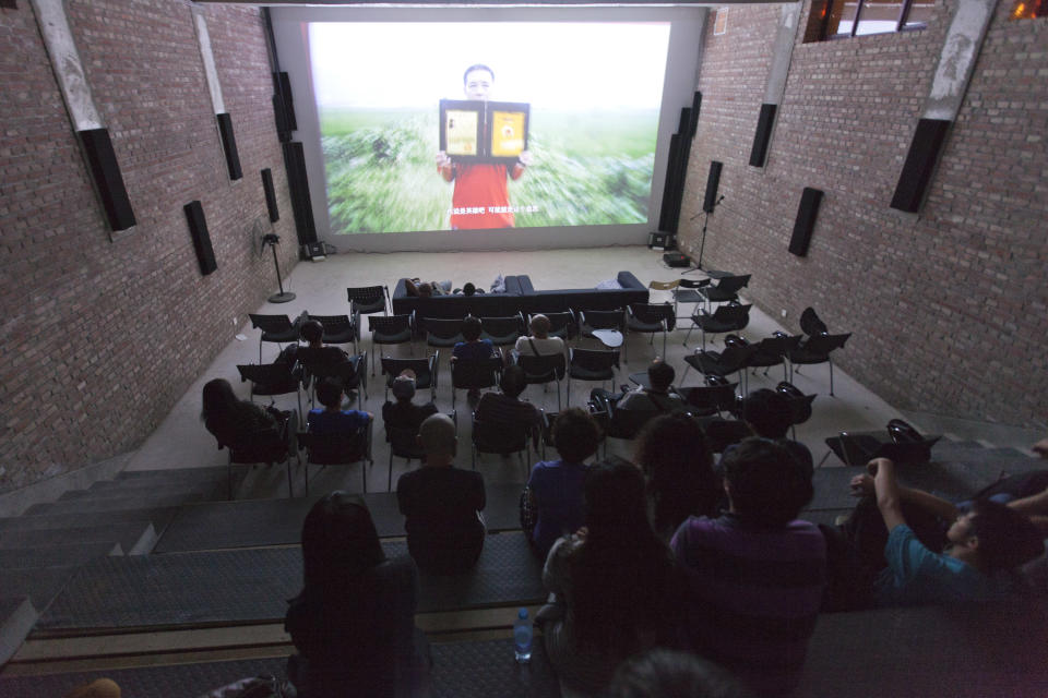 People watch a documentary film about Qian Yunhui, who died fighting for better compensation for seized land, at the Beijing Independent Film Festival in Beijing, China, Friday, Aug. 30, 2013. Chinese authorities have disrupted an independent film school, shut down two film festivals and harassed organizers of a third in recent months, say independent filmmakers, who see the moves as part of a general clampdown on freedom of expression. (AP Photo/Alexander F. Yuan)