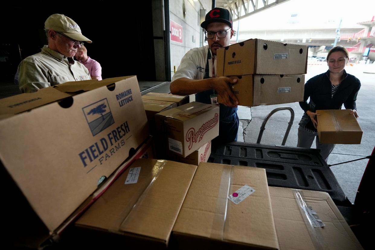 Executive Chef Gary Davis (center) and Commissary Manager Brooke Mullins (right) load up food donations from their employer, Great American Ball Park concession operator Delaware North. Delaware North has been donating leftovers to Last Mile Food Rescue after Cincinnati Reds' home stands since 2021.