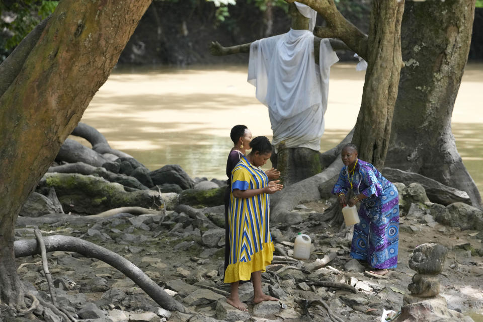 Devotees of the Osun River goddess pray in Osogbo, Nigeria, on Sunday, May 29, 2022. They have little interaction with outsiders, allowing them to devote themselves fully to the goddess, whom they worship daily at a shrine tucked deep inside the grove. (AP Photo/Sunday Alamba)