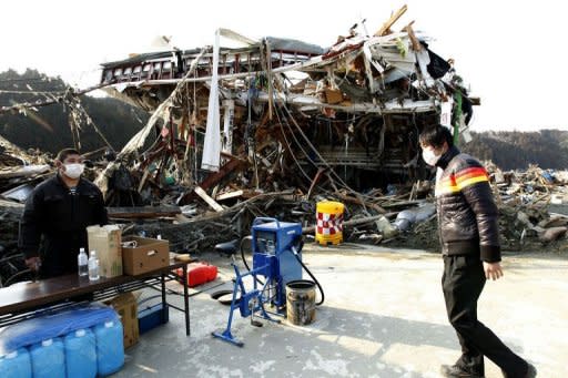 Staff members man a filling station in Minamisanriku, Miyagi prefecture which has started selling fuel for emergency vehicles. Crews fighting to cool reactors at Japan's stricken nuclear plant managed to connect a power line Saturday as the government revealed that leaking radioactivity had reached the food chain