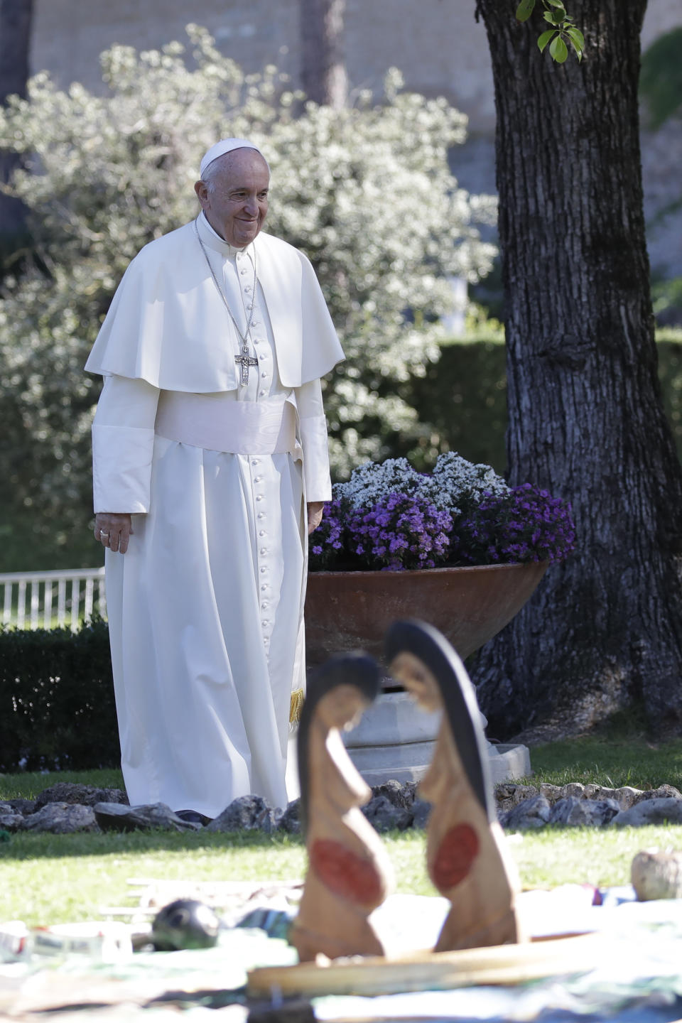 In this photo taken on Friday, Oct. 4, 2019, Pope Francis walks past wooden statues portraying naked pregnant women as he arrives to attend a tree planting rite with members of Amazon indigenous populations, in the Vatican gardens. Pope Francis’ meeting on the Amazon is wrapping up after three weeks of debate over married priests, the environment _ and the destruction of indigenous statues that underscored the willingness of conservatives to violently vent their opposition to the pope. (AP Photo/Alessandra Tarantino)