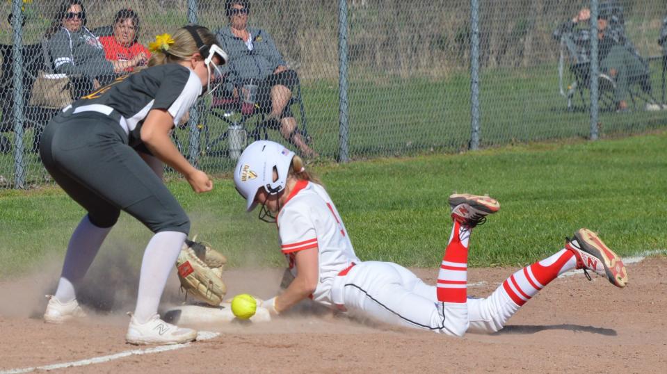 New Boston Huron’s Marissa Jackson slides safely into third base as Kennedy Kroll of Airport takes the throw during a 7-6 Airport win on Monday, April 15, 2024.