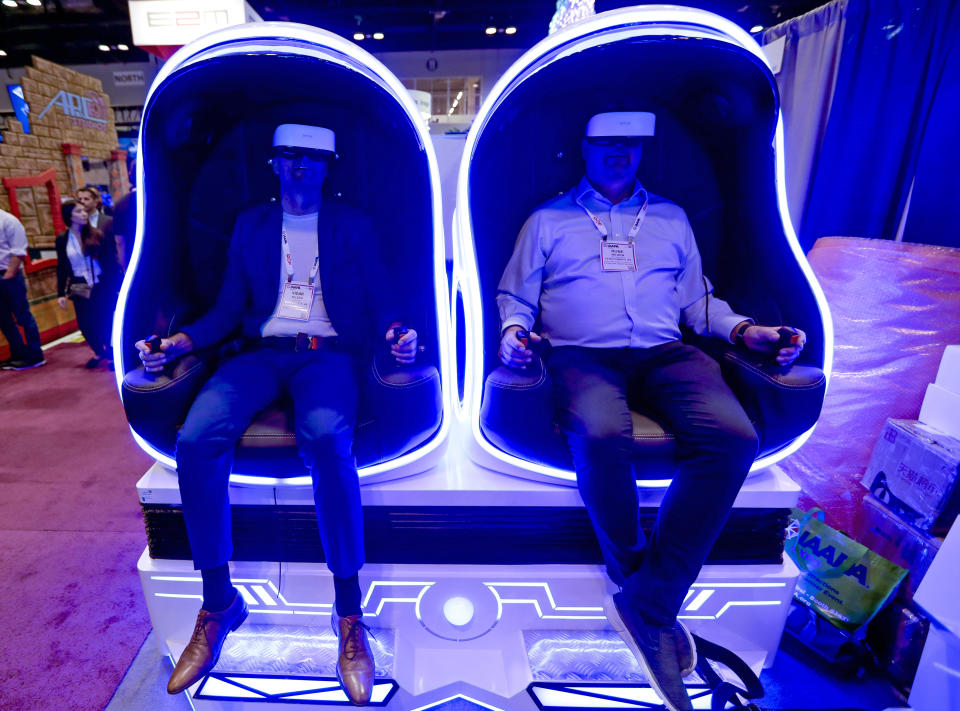 Attendees sample one of the many virtual reality rides during the International Association of Amusement Parks and Attractions convention Tuesday, Nov. 19, 2019, in Orlando, Fla. (AP Photo/John Raoux)
