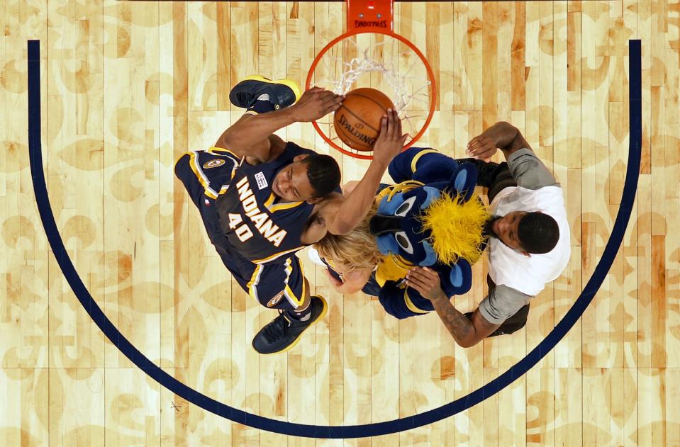 Glenn Robinson III throws down a reverse after leaping over Paul George, Pacers mascot Boomer and a Pacers dancer. (AP)