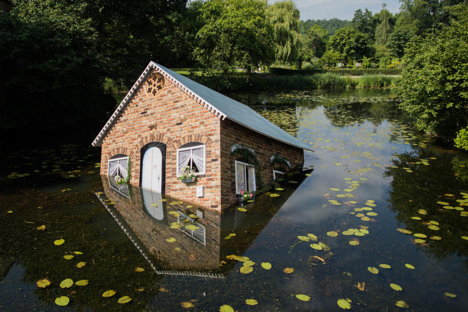 <p>Die Installation „Atlantis“ der finnischen Künstlerin Tea Mäkipää ist derzeit im Museum Schloss Moyland in nordrhein-westfälischen Bedburg-Hau zu sehen. Das im Schlossgraben versinkende Haus ist ein Publikumsmagnet. (Bild: Rolf Vennenbernd/dpa) </p>