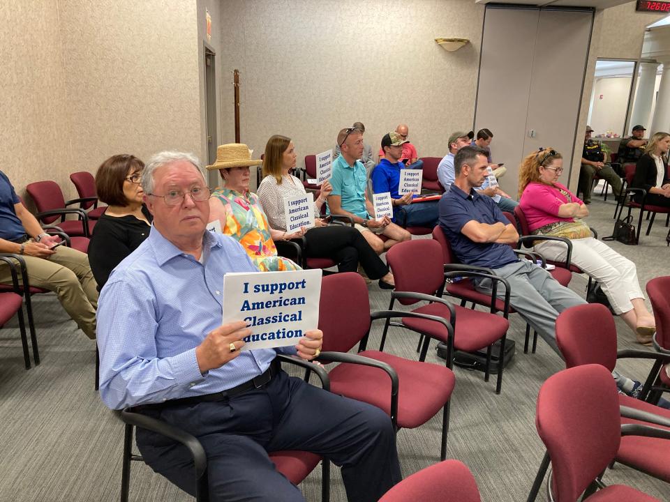 Mark Hutchinson,left, joins others holding a sign that says, "I support American Classical Education,"  before the Rutherford County Board of Education rejected the charter school application that has ties to Hillsdale College.