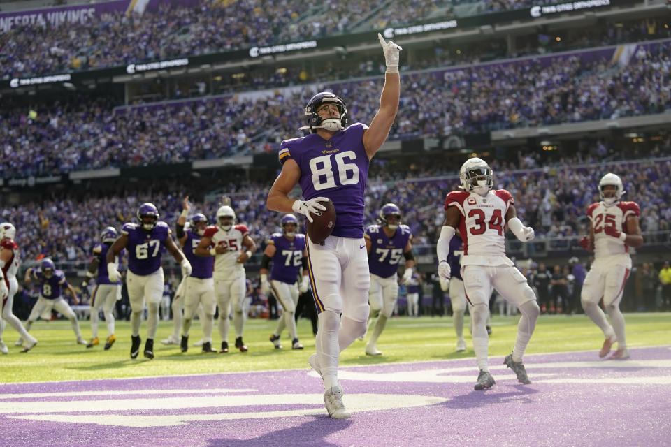 Minnesota Vikings tight end Johnny Mundt (86) celebrates ahead of Arizona Cardinals safety Jalen Thompson (34) after catching a 1-yard touchdown pass during the first half of an NFL football game, Sunday, Oct. 30, 2022, in Minneapolis. (AP Photo/Abbie Parr)