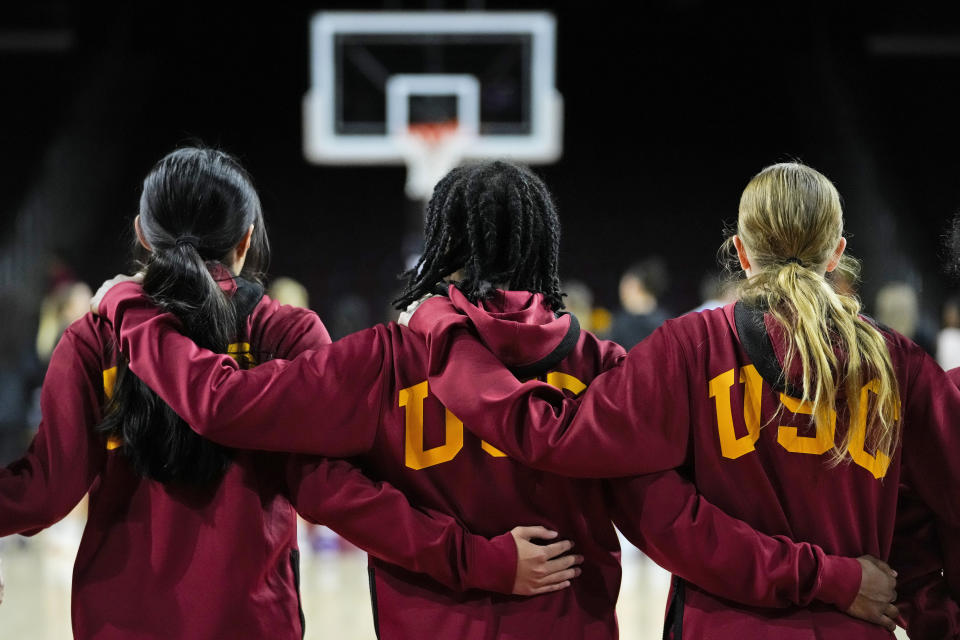 Southern California guard Aaliyah Gayles, center, stands with teammates as the national anthem is played before the team's NCAA college basketball game against Washington in Los Angeles, Sunday, Jan. 28, 2024. (AP Photo/Ashley Landis)