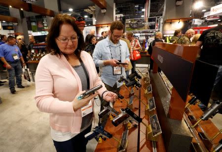 Cindy Pelletier of Alpharetta, Georgia, looks over a semi-automatic handgun Kimber Micro Bel Air, a .380 ACP caliber, during the SHOT (Shooting, Hunting, Outdoor Trade) Show in Las Vegas, Nevada, U.S., January 22, 2019. Picture taken January 22, 2019. REUTERS/Steve Marcus