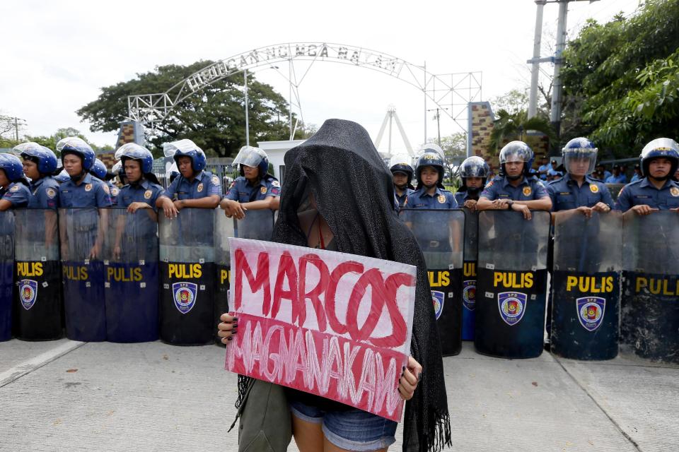 A protester displays a "Marcos, Thief" placard during a rally at the Heroes Cemetery to protest the hero's burial of the late Philippine dictator Ferdinand Marcos as the nation marks the 31st anniversary of the People Power revolution that toppled the Marcoses from 20-year-rule Saturday, Feb. 25, 2017, in suburban Taguig city, east of Manila, Philippines. President Rodrigo Duterte, who expressed his support for the Marcoses, skipped the celebration, the first time by a sitting president. (AP Photo/Bullit Marquez)