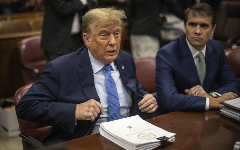 Mr Trump takes his seat before the start of proceedings on Friday