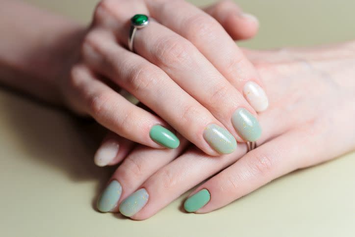 female hands with nail design close up of an ombre green manicure