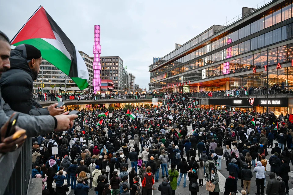 Demonstrators waved flags and displayed placards during a demonstration in solidarity with Palestinians in the Gaza Strip, at Sergel's Square in Stockholm, Sweden on Oct. 22. (Photo by Pontus Lundahl/TT NEWS AGENCY/AFP via Getty Images)