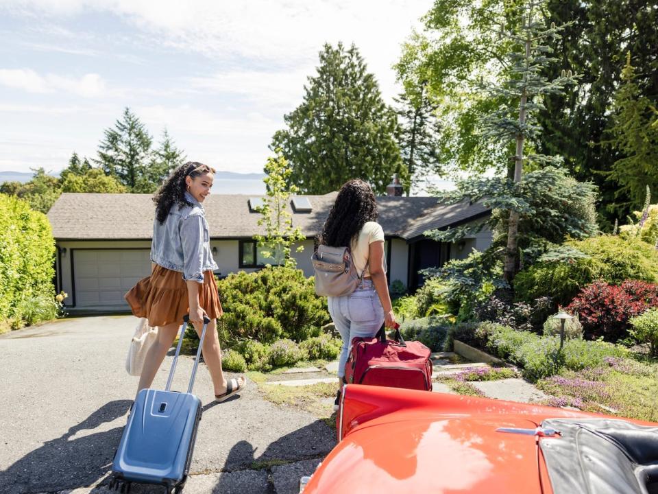 Two travelers leave a vacation rental.