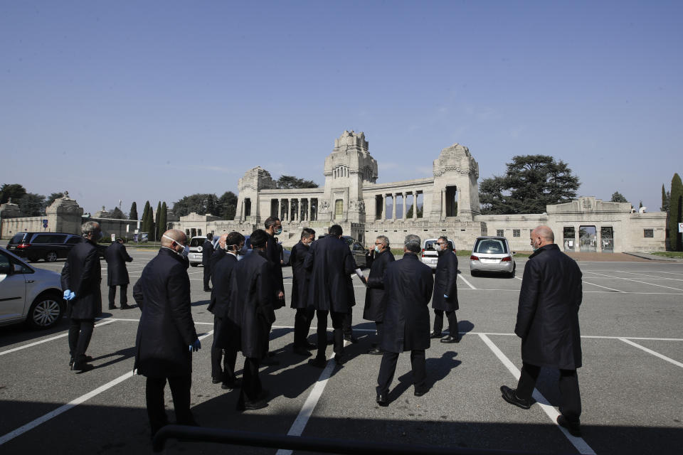 FILE - In this Tuesday, March 17, 2020 file photo, pallbearers stand outside the Monumentale cemetery, in Bergamo, the heart of the hardest-hit province in Italy's hardest-hit region of Lombardy, Italy. Italy is poised to reclaim the dishonor of reporting the most coronavirus deaths in Europe, as the second surge ravages the country’s disproportionately old population and exposes how public health shortfalls and delayed restrictions compounded a lack of preparedness going into the pandemic. (AP Photo/Luca Bruno, File)