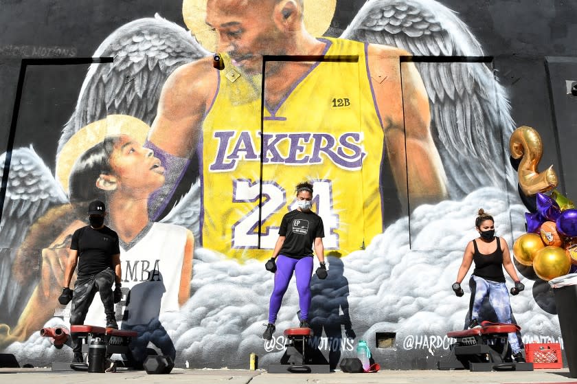 LOS ANGELES, CALIFORNIA JANUARY 26, 2021-People workout in front of a mural of Lakers legend Kobe Bryant and his daughter Gianna on the 1-year anniversary of their death outside of Hardcore Fitness Bootcamp in Downtown Los Angeles Tueswday. (Wally Skalij/Los Angeles Times)