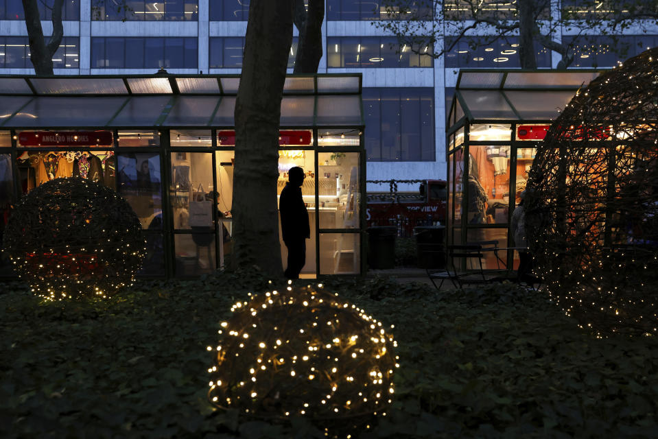 People browse shops in Bryant Park's Winter Village, Tuesday, Nov. 15, 2022, in New York. After two years of pandemic holidays when people spent more dollars online, shoppers are back in force in stores and at holiday markets. Small businesses say it is beginning to feel a lot like Christmas, both emotionally and financially. (AP Photo/Julia Nikhinson)