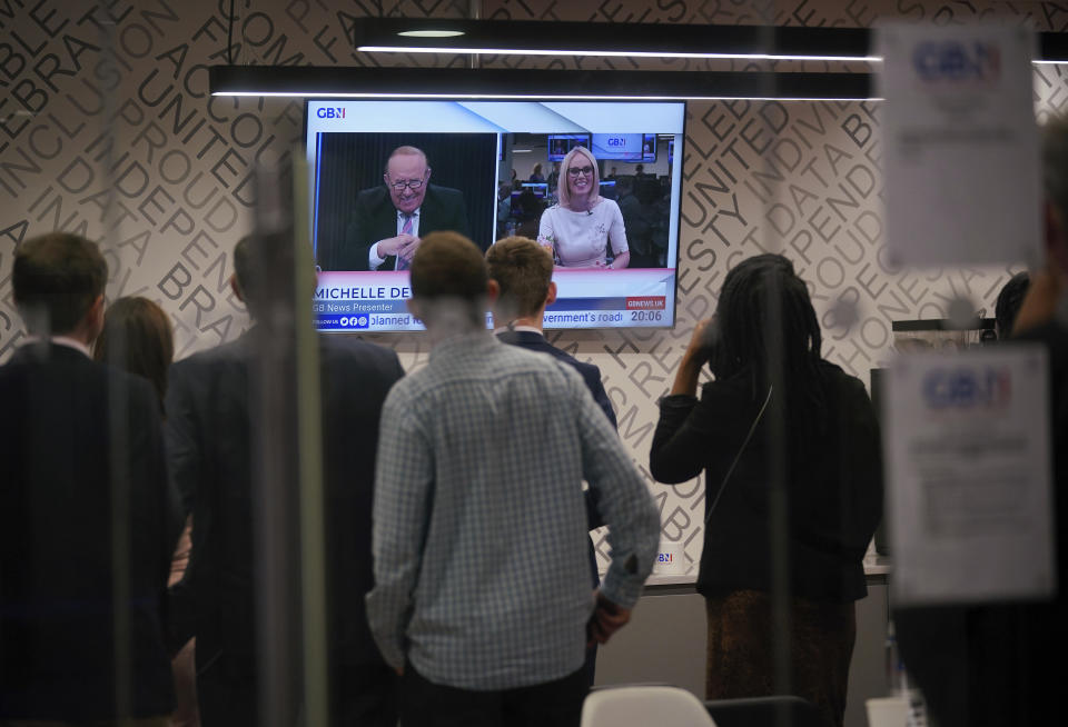 Staff in the green room watch a television screen showing presenters Andrew Neil and Michelle Dewberry broadcast from a studio, during the launch event for new TV channel GB News in London, Sunday June 13, 2021. A new news channel launched on British television on Sunday evening with the aim of giving a voice “to those who feel sidelined or silenced.” GB News, which is positioning itself as a rival to the news and current affairs offerings of the likes of BBC and Sky News, denies it will be the British equivalent of Fox News. However, it clearly wants to do things differently. (Yui Mok/PA via AP)