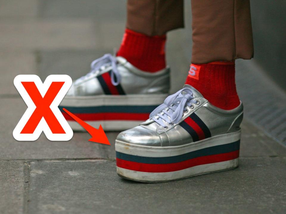 red x and arrow pointing at red, green, and silver platform sneakers someone is wearing with brown pants